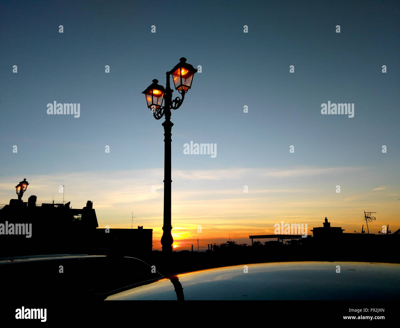 Streetlamp silhouette against a sunset sky Stock Photo
