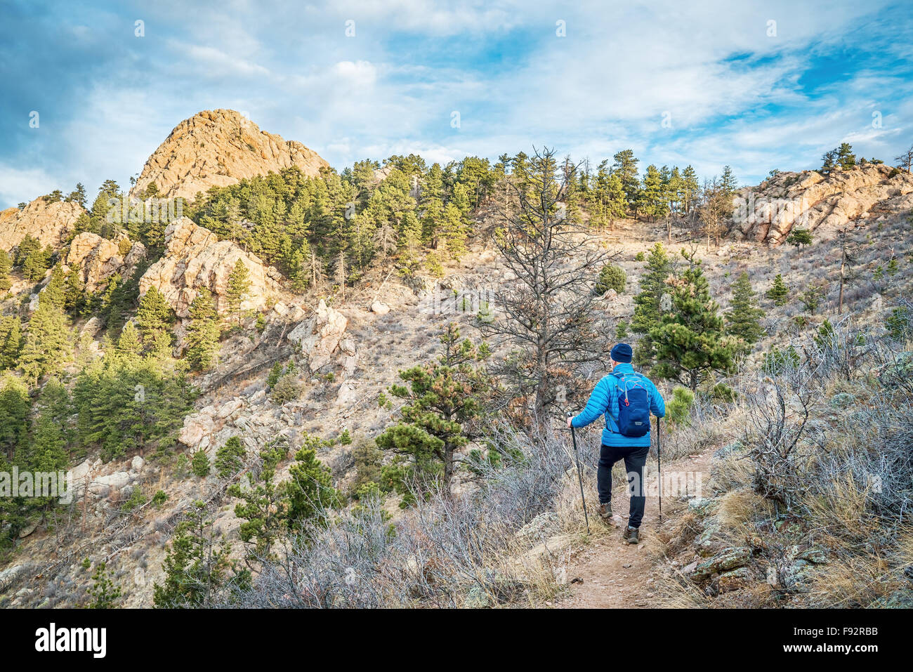 mail hiker with a backpack on a trail to Horsetooth Rock, a landmark of Fort Collins, Colorado, winter scenery without snow Stock Photo