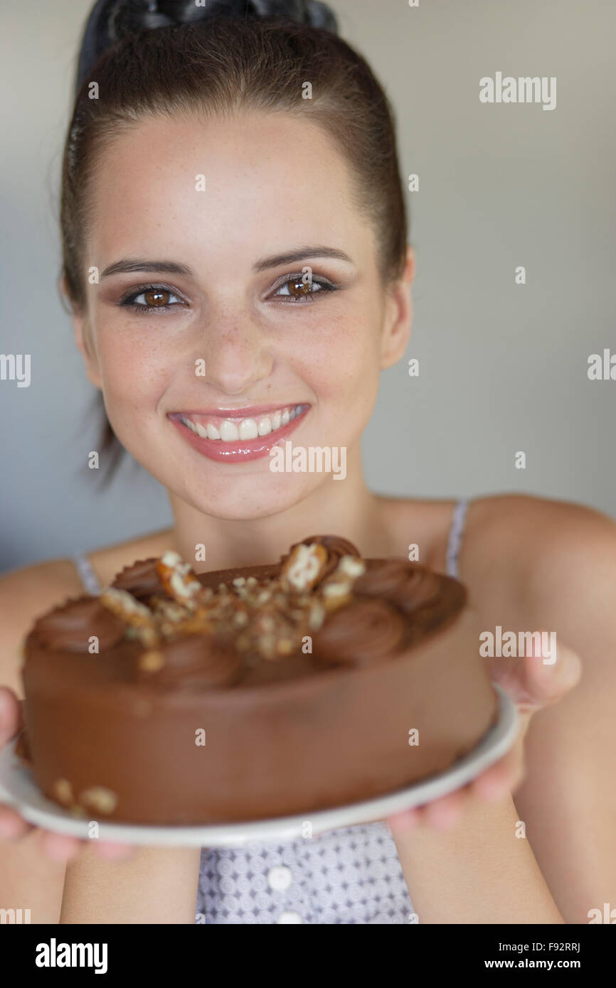 Young woman holding a chocolate cake Stock Photo