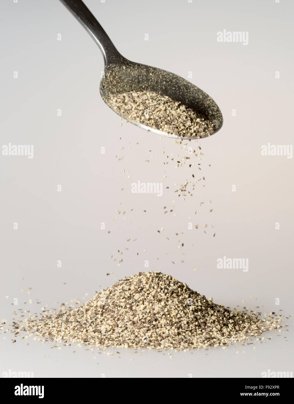 Black Pepper Falling from tablespoon Stock Photo