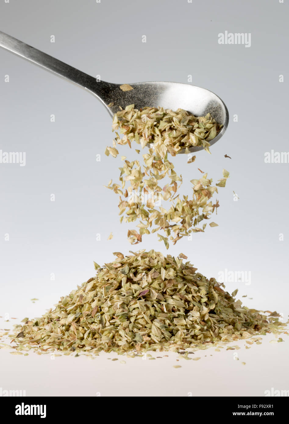 Dried Oregano Falling from Tablespoon Stock Photo