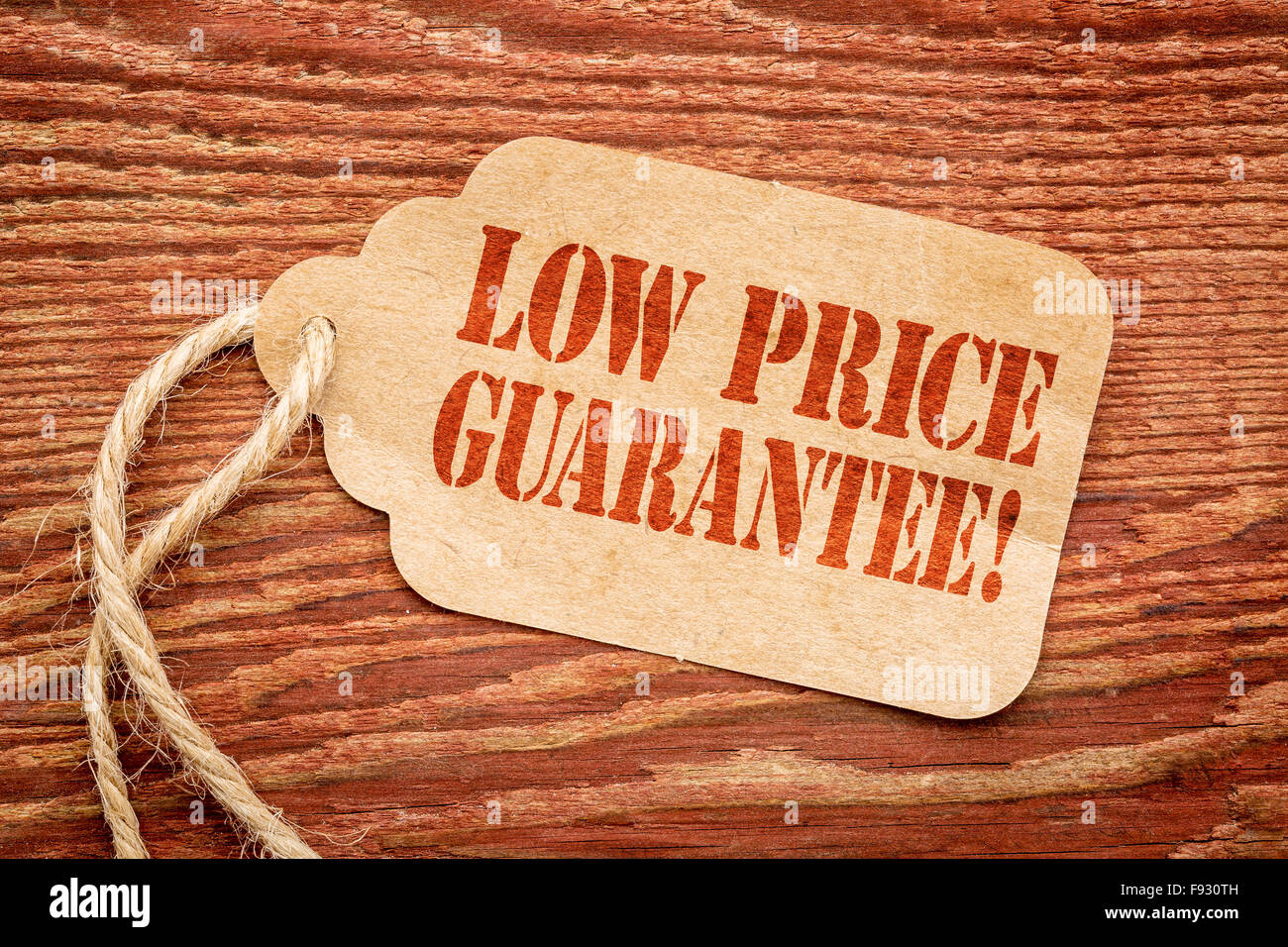 low price guarantee - sign on paper price tag against a rustic barn wood Stock Photo