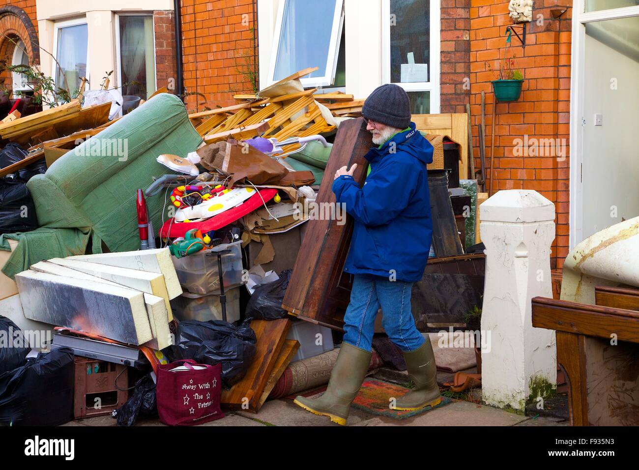 Cumbrian Floods. Carlisle, Cumbria, UK. 13 December 2015. Man taking out his flood damaged property being taken outside flooded houses. Flooding caused by Storm Desmond. Credit:  Andrew Findlay/Alamy Live News Stock Photo