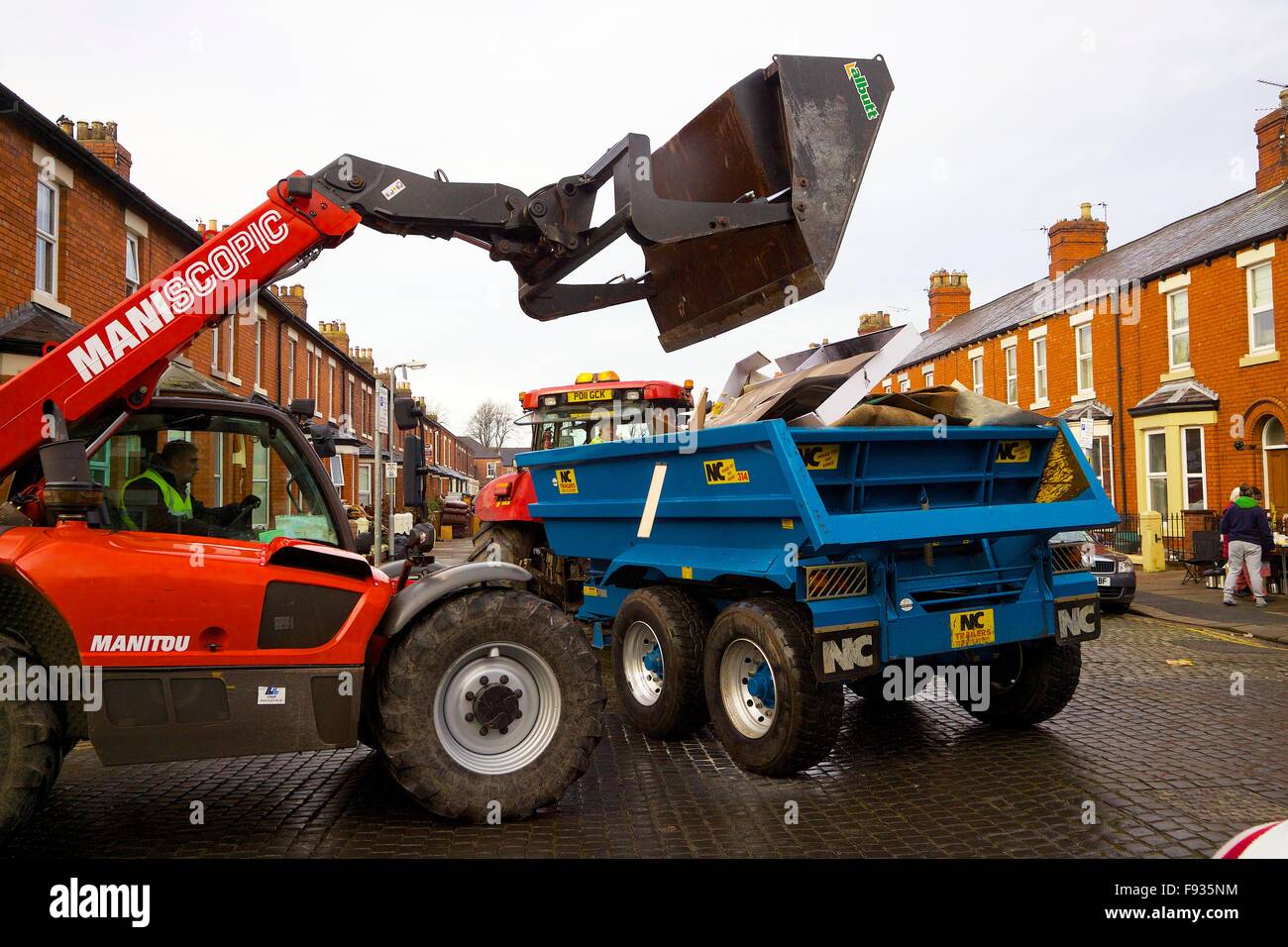 Carlisle, Cumbria, UK. 13 December 2015. Flood damaged property being loaded into agricultural trailer for disposal outside flooded out houses. Flooding caused by Storm Desmond. Credit:  Andrew Findlay/Alamy Live News Stock Photo