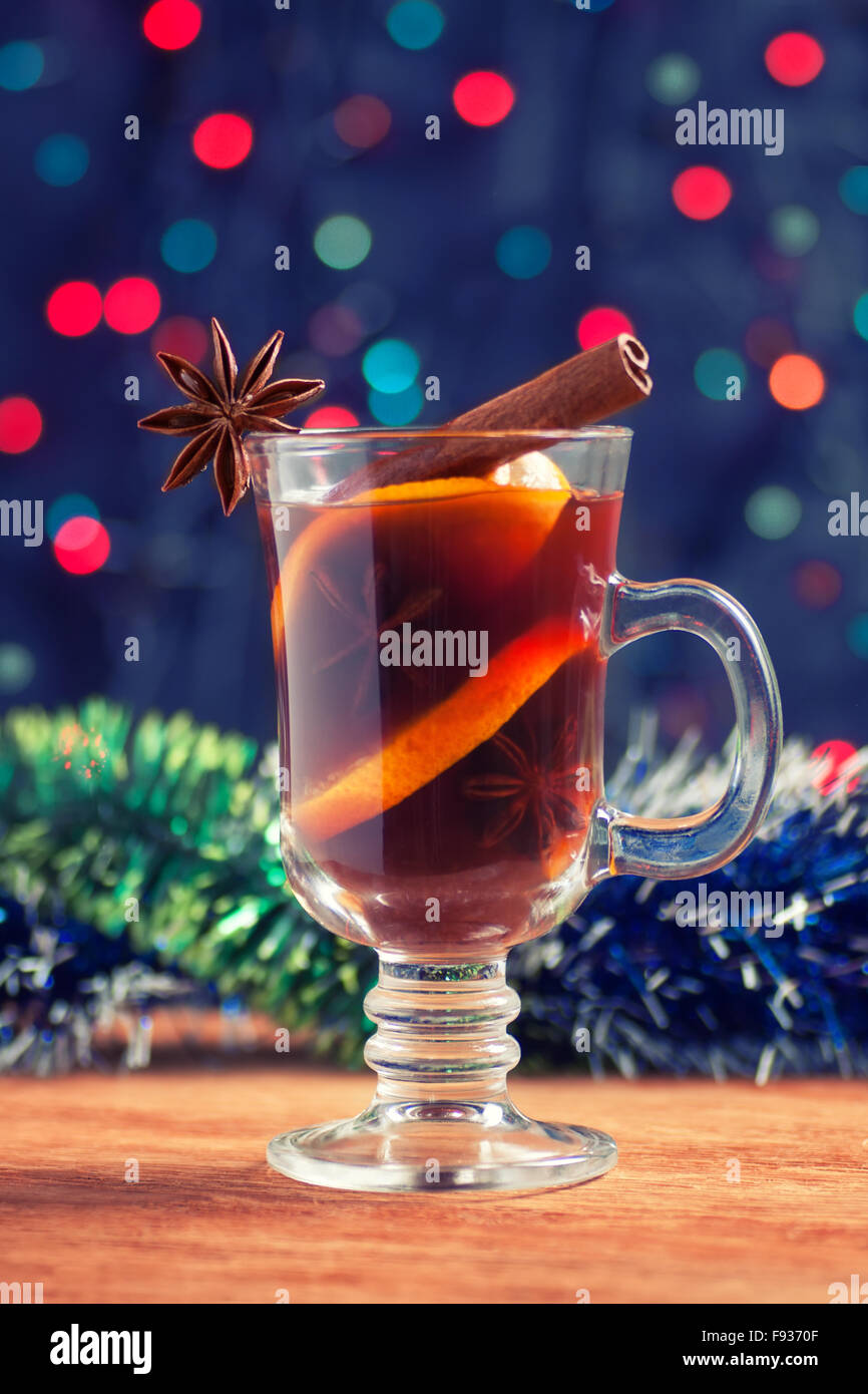 Christmassy mulled wine with tinsel on a wooden table on bokeh background Stock Photo