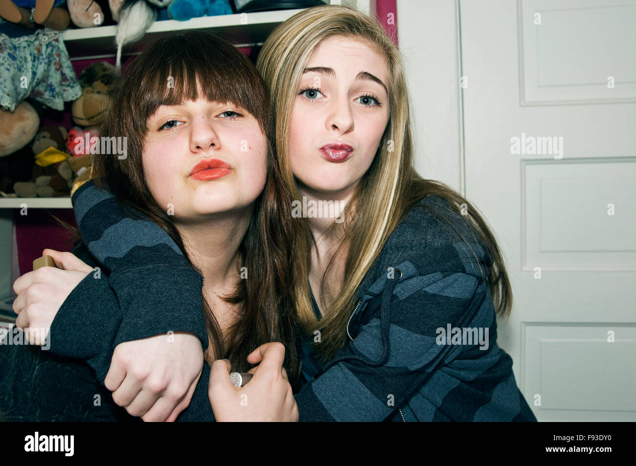 Two teenage girls making faces at the camera while wearing lipstick. (13-16 years old) Stock Photo
