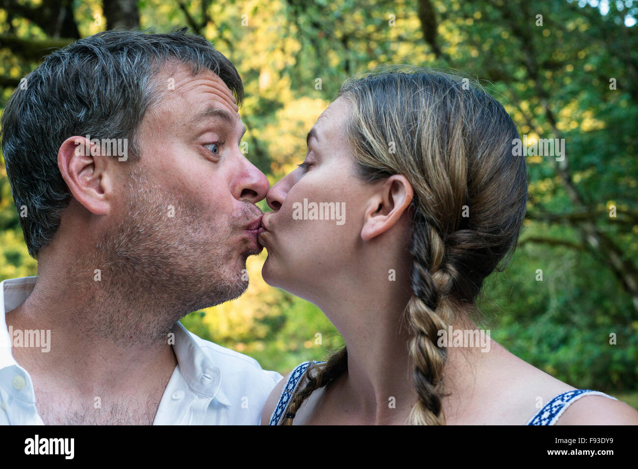 A man and a woman in their 40's kissing in a platonic way. Stock Photo