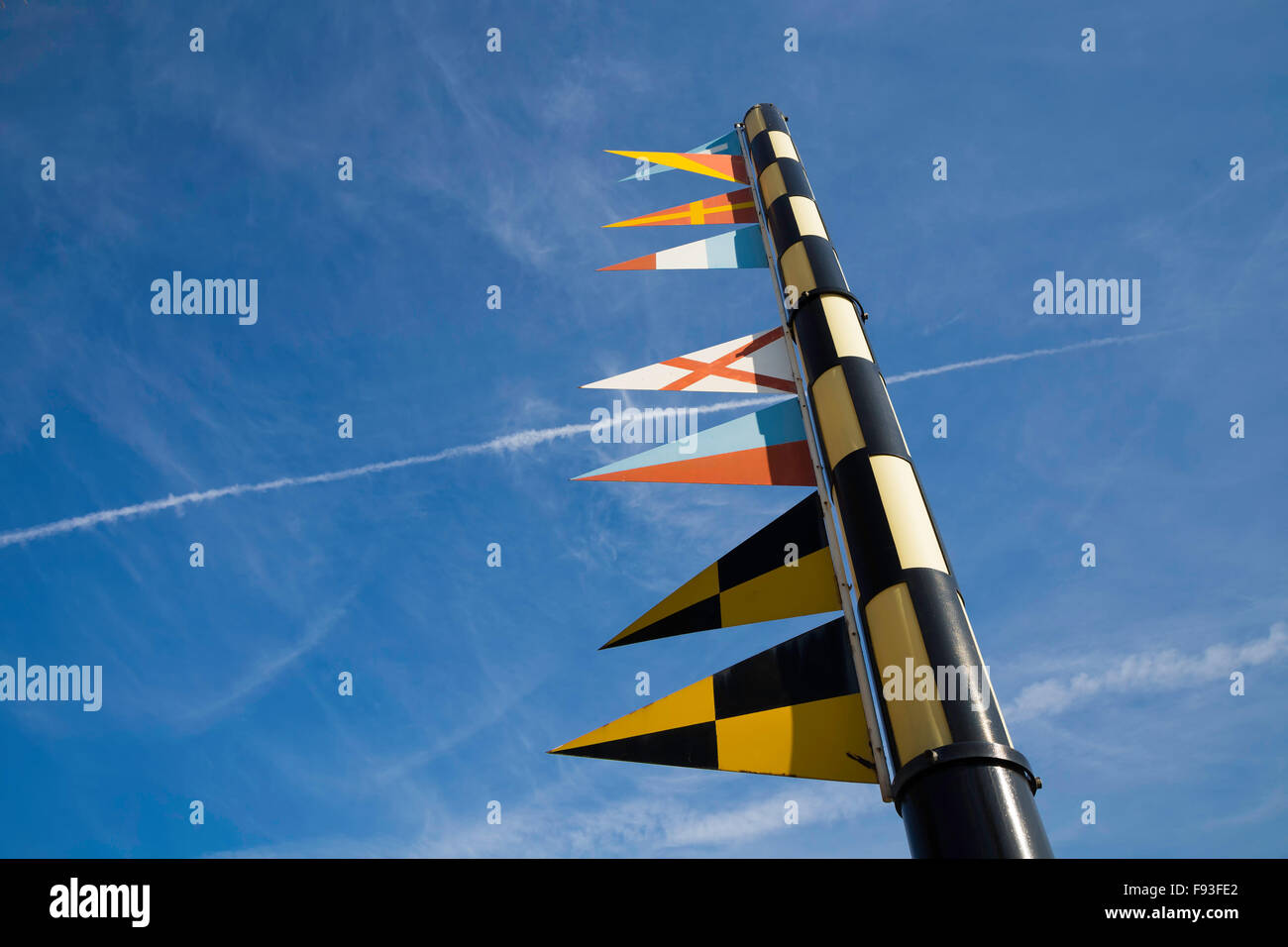 Nautical signal flags on a flagpole against blue sky Stock Photo