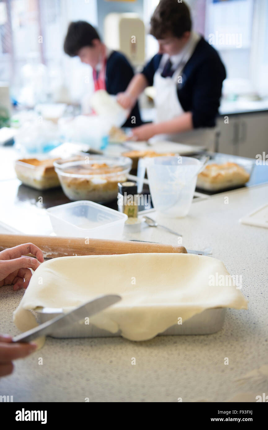 Secondary education Wales UK: Boy Pupils preparing to cook food in a food technology (domestic science) school teaching kitchen classroom Stock Photo