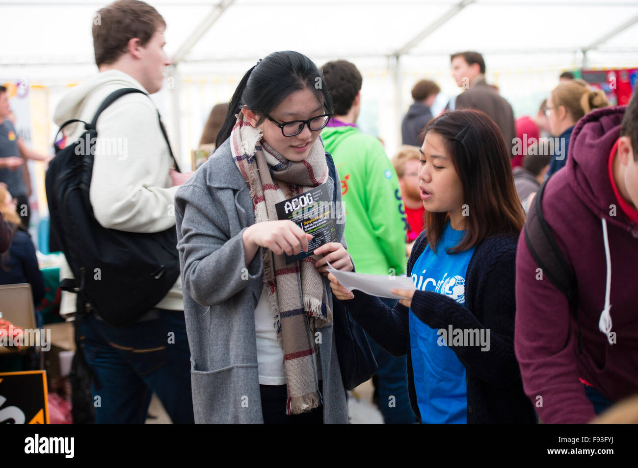 Freshers Week at University UK: Two young Chinese women, Aberystwyth university undergraduate overseas students,  signing up to join social and community groups and  societies at the Freshers Fair in the opening week of the academic year,September 2015,, Wales UK Stock Photo