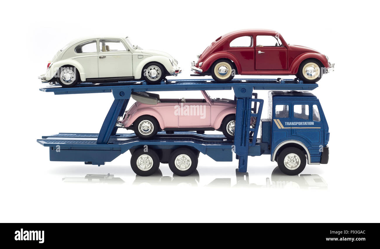 Three Vintage VW Beetles  on a car Transporter on a white background. Stock Photo