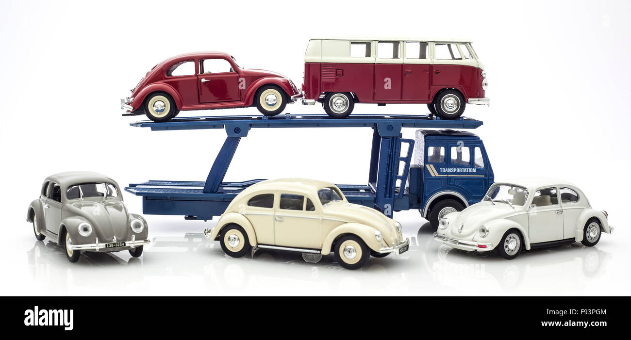 Vintage VW Beetles and Camper Van on a car Transporter on a white background. Stock Photo