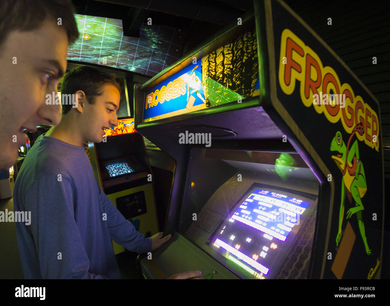 Garden City, New York, USA. 12th Dec, 2015. SETH ROSEN, 15, at right, from Roslyn, NY, and his cousin JACOB ROSEN, 21, from Miami, FLA, play FROGGER, a 1981 Sega Gremlin game, during Opening Day of Arcade Age exhibit, where visitors experience playing authentic classic games in arcade set up at Cradle of Aviation Museum in Long Island. Admission includes unlimited free pay-to-play of video arcade games, and games history is displayed outside arcade area. Exhibit runs from Dec. 12, 2015 through April 3, 2016. © Ann Parry/ZUMA Wire/Alamy Live News Stock Photo