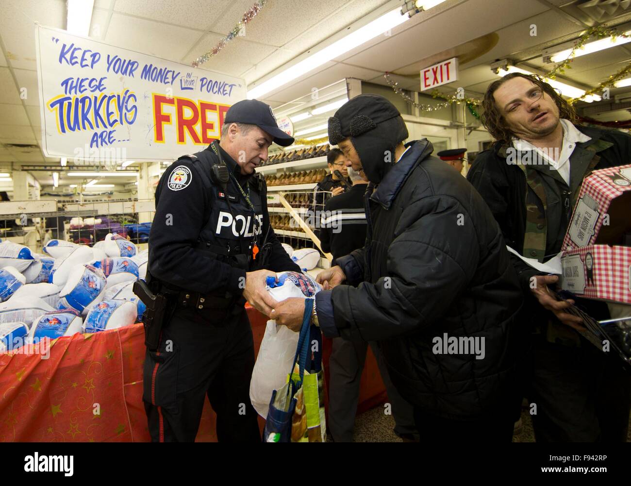 Toronto, Canada. 13th Dec, 2015. People receive free turkeys at a local store called Honest Ed's during the store's 28th annual Christmas time turkey giveaway event in Toronto, Canada, Dec. 13, 2015. In the last giveaway of this annual event, hundreds of people around the city lined up to get one of about 1,300 free turkeys and fruitcakes from the store on Sunday. © Zou Zheng/Xinhua/Alamy Live News Stock Photo