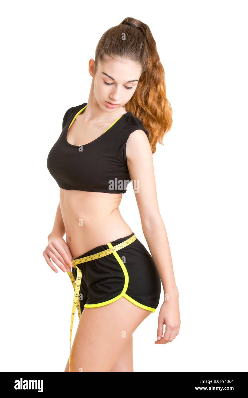 Woman measuring her waist with a yellow measuring tape, isolated in white Stock Photo