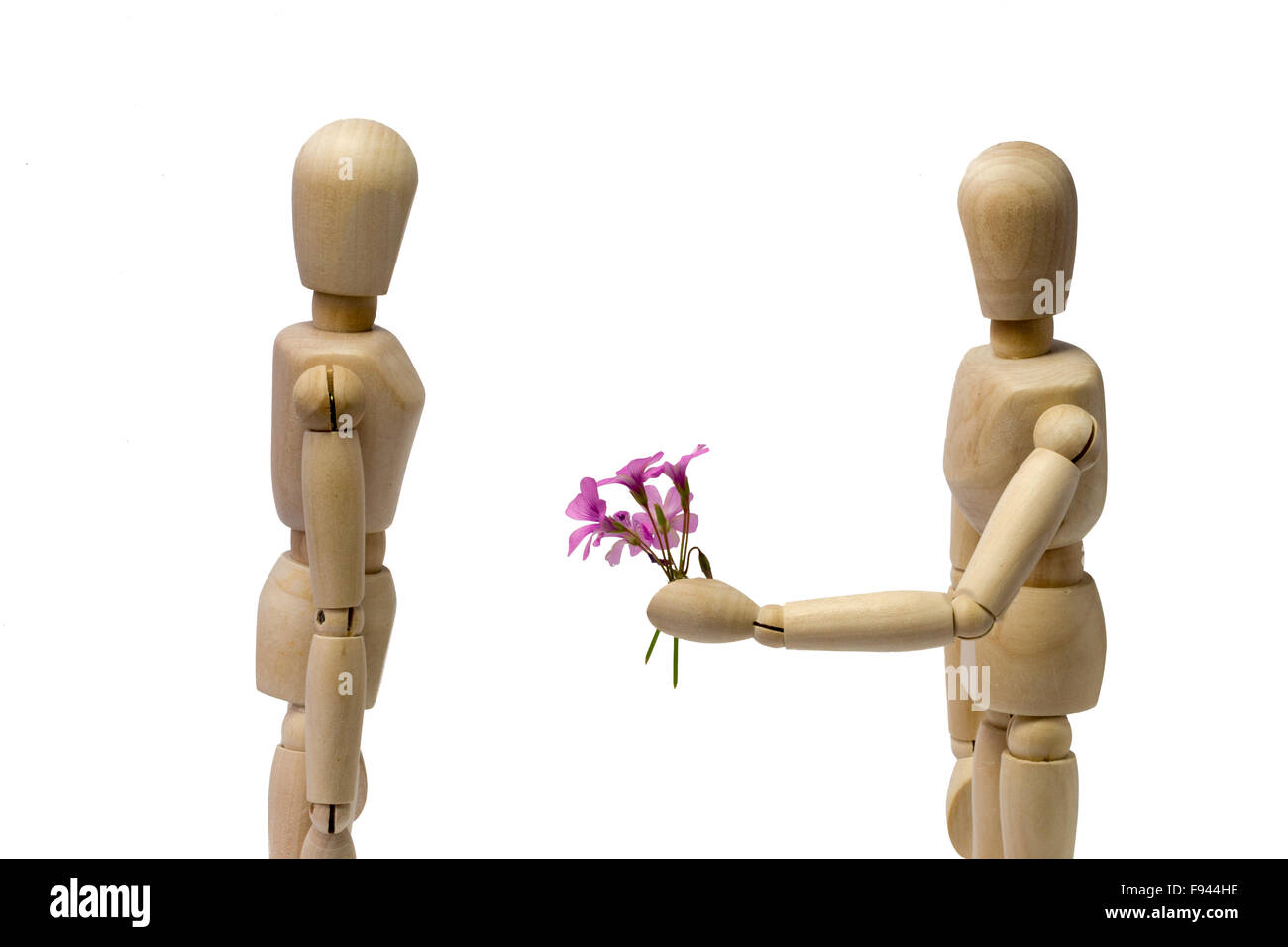 Male puppet brings woman some flowers on white background Stock Photo