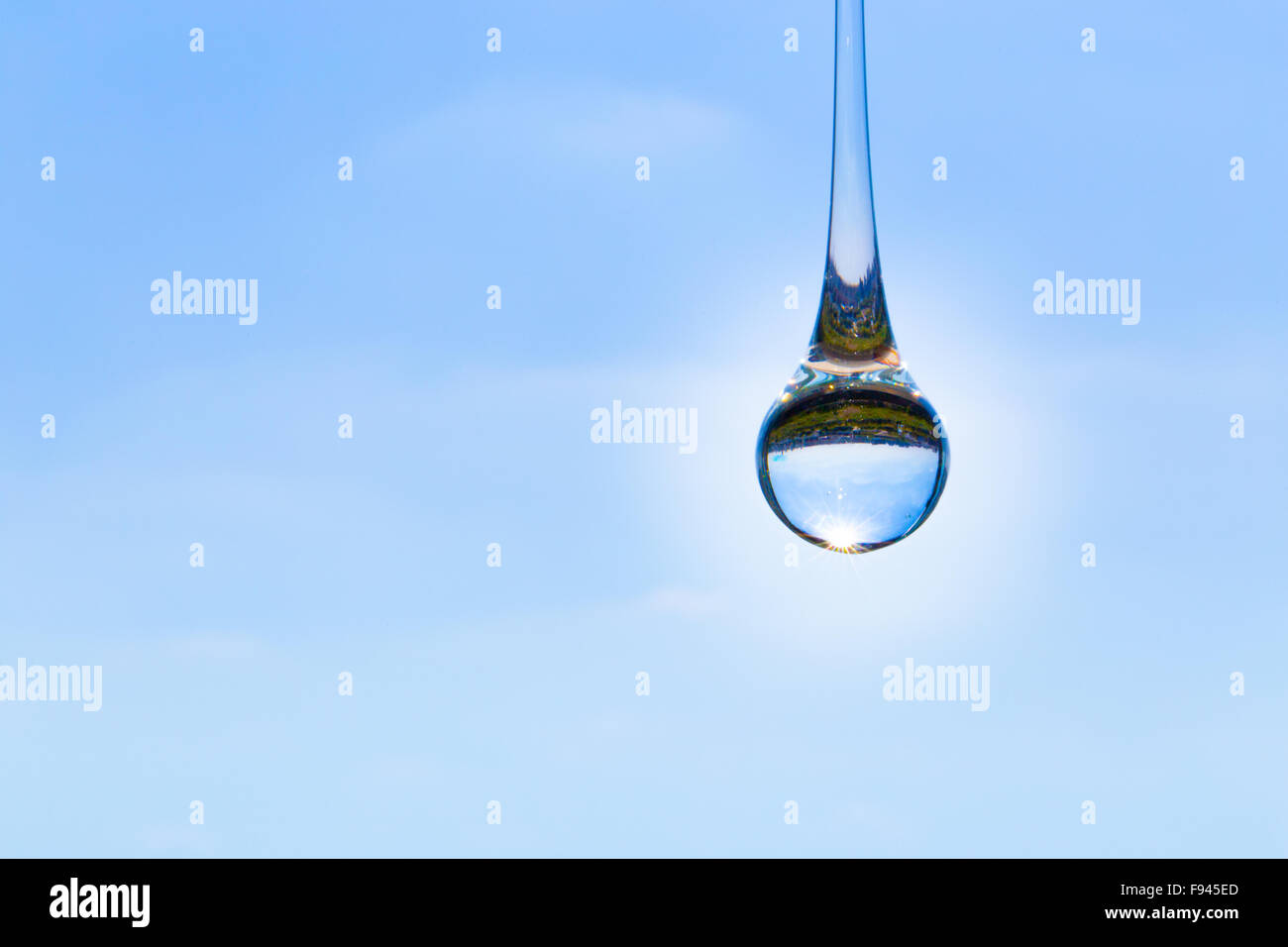 Glass raindrop on blue sky and a reflection of the landscape Stock Photo