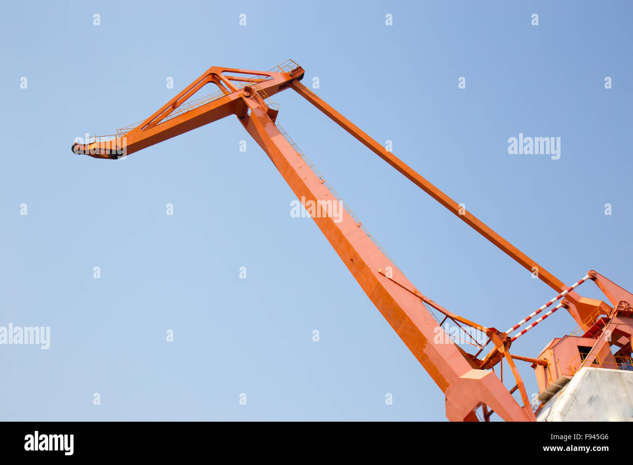 Huge orange cargo crane in front of blue sky Stock Photo