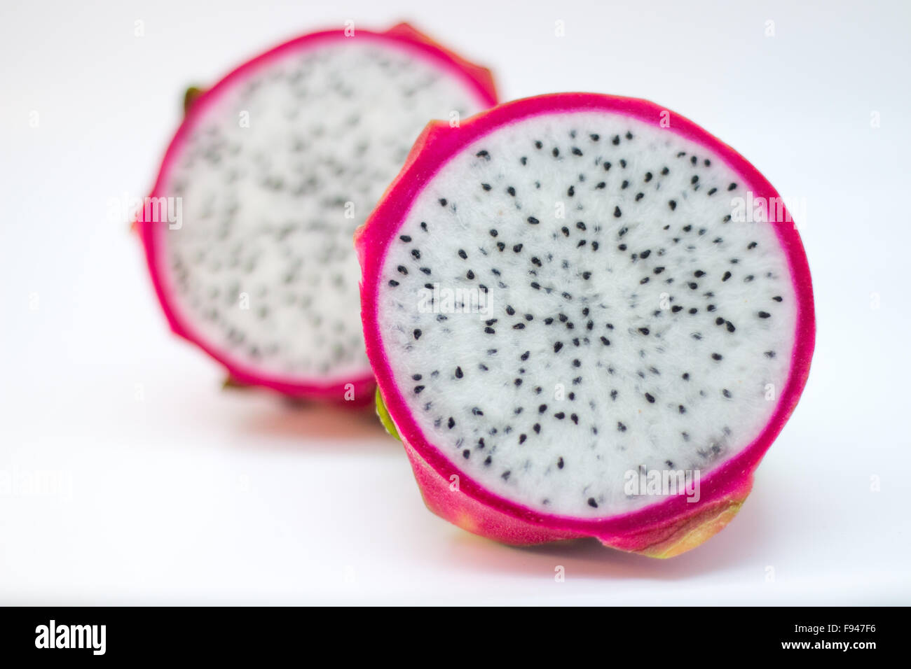 Whole dragonfruit cut in half from the back with a blurry front Stock Photo