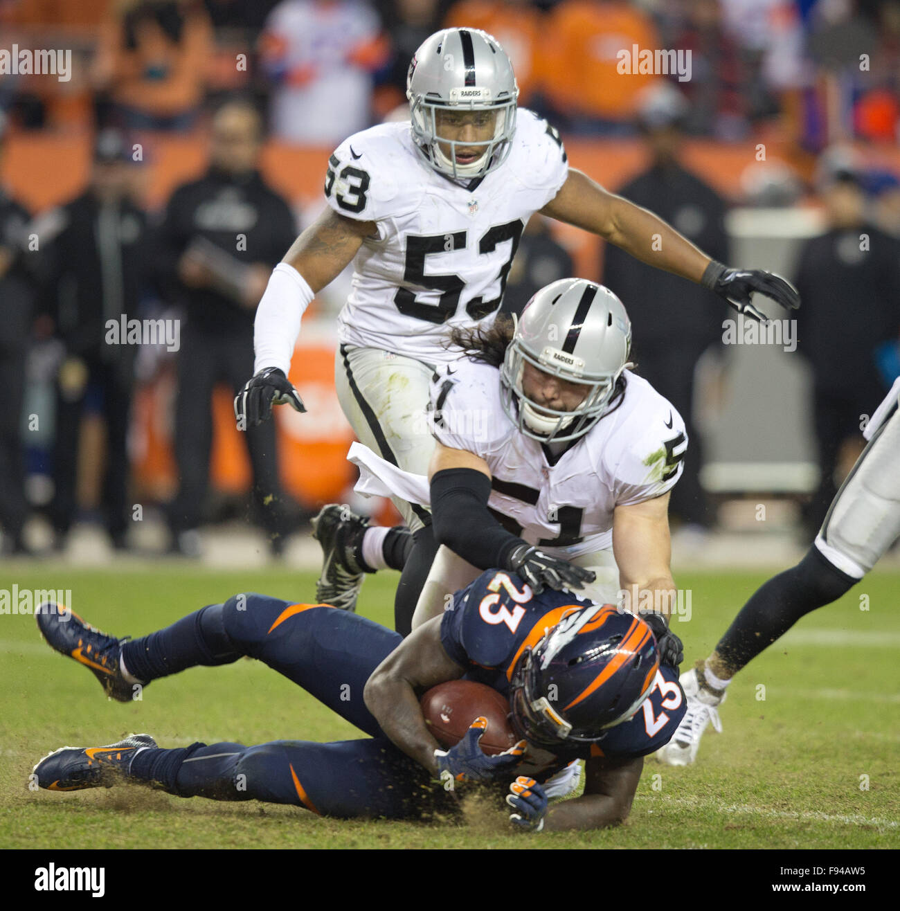 Denver, Colorado, USA. 13th Dec, 2015. Broncos RB RONNIE HILLMAN, bottom, gets tackled by Raiders LB BEN HEENEY, center, during the 2nd. Half at Sports Authority Field at Mile High Sunday afternoon. The Raiders beat the Broncos 15-12. Credit:  Hector Acevedo/ZUMA Wire/Alamy Live News Stock Photo