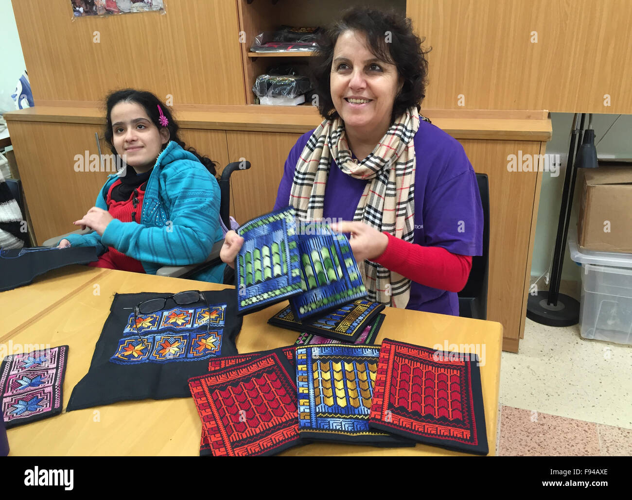 Beit Jala, Palestine. 09th Dec, 2015. Two employees show off ...