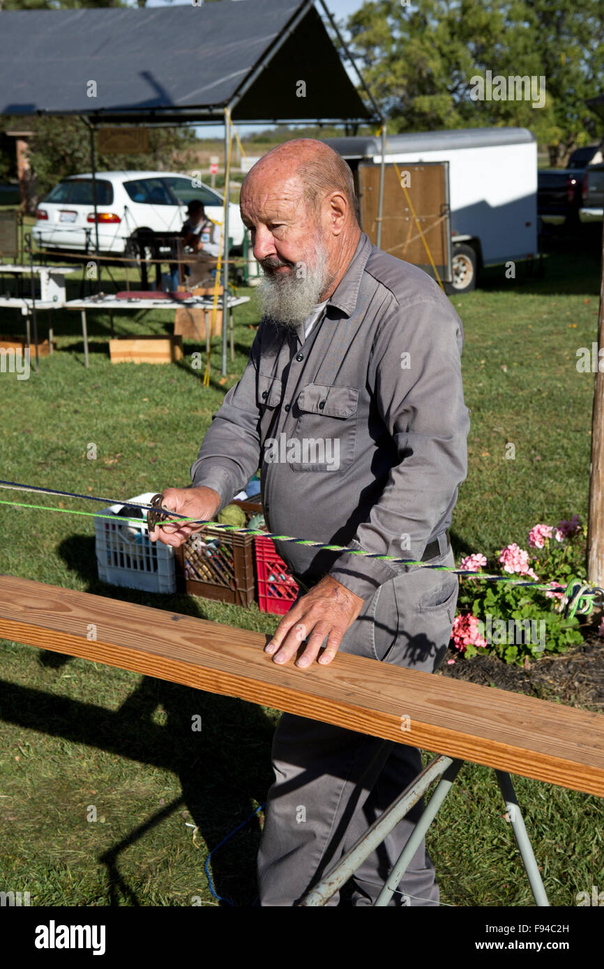Man demonstrating traditional rope making equipment and techniques