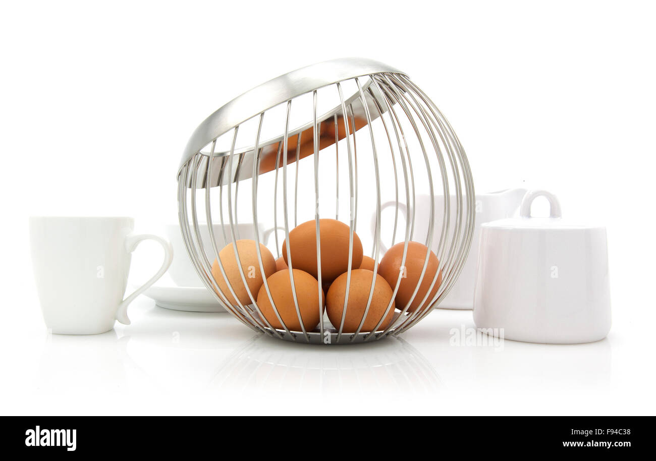 A modern wire basket of eggs in a contemporary white kitchen setting Stock Photo