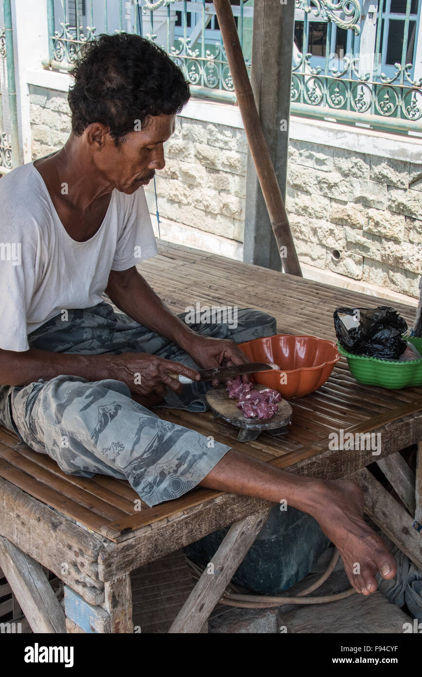 Man preparing goat meat outside, Surabaya, Indonesia Stock Photo