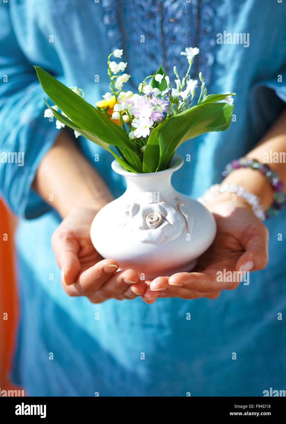 Woman Holding Bouquet Of Flower In Vase. Blue Clothing Background Stock 