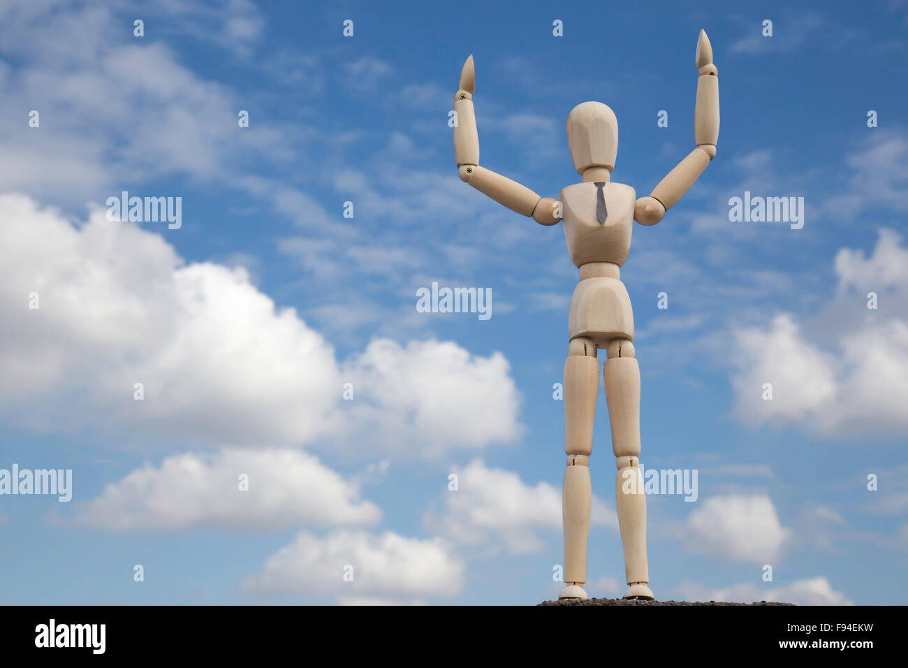 Businessman on top of the world in front of blue cloudy sky Stock Photo