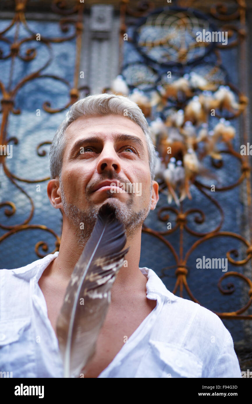 Sexi Man in a white shirt and ornamental window on background. And ...