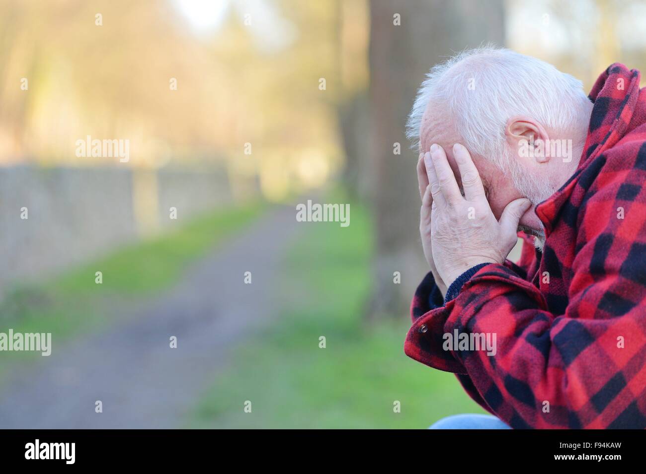 Elderly man sitting on a bank thinking, Germany, city of Osterode, 10. December 2015. Photo: Frank May Stock Photo