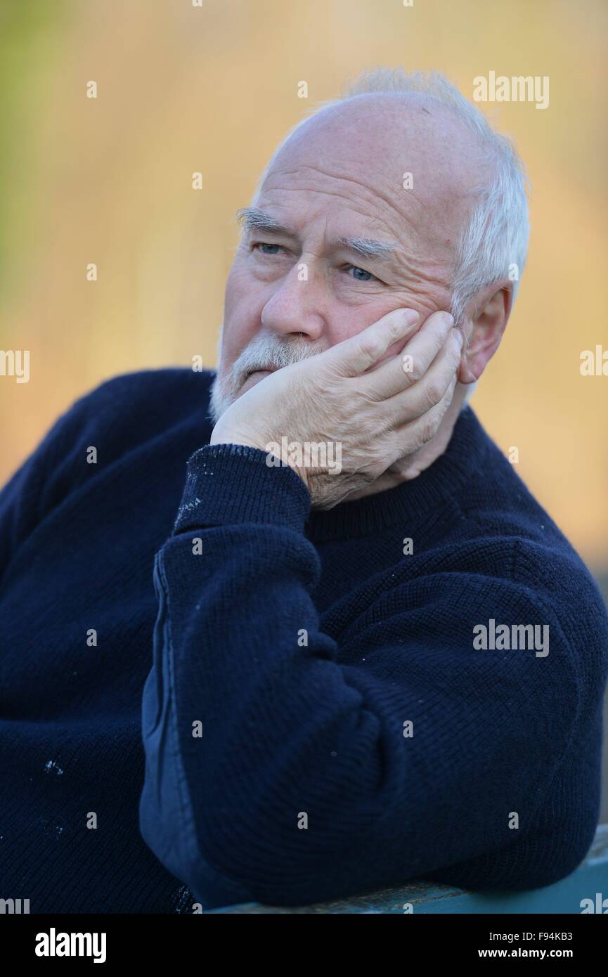 Elderly man sitting on a bank thinking, Germany, city of Osterode, 10. December 2015. Photo: Frank May Stock Photo