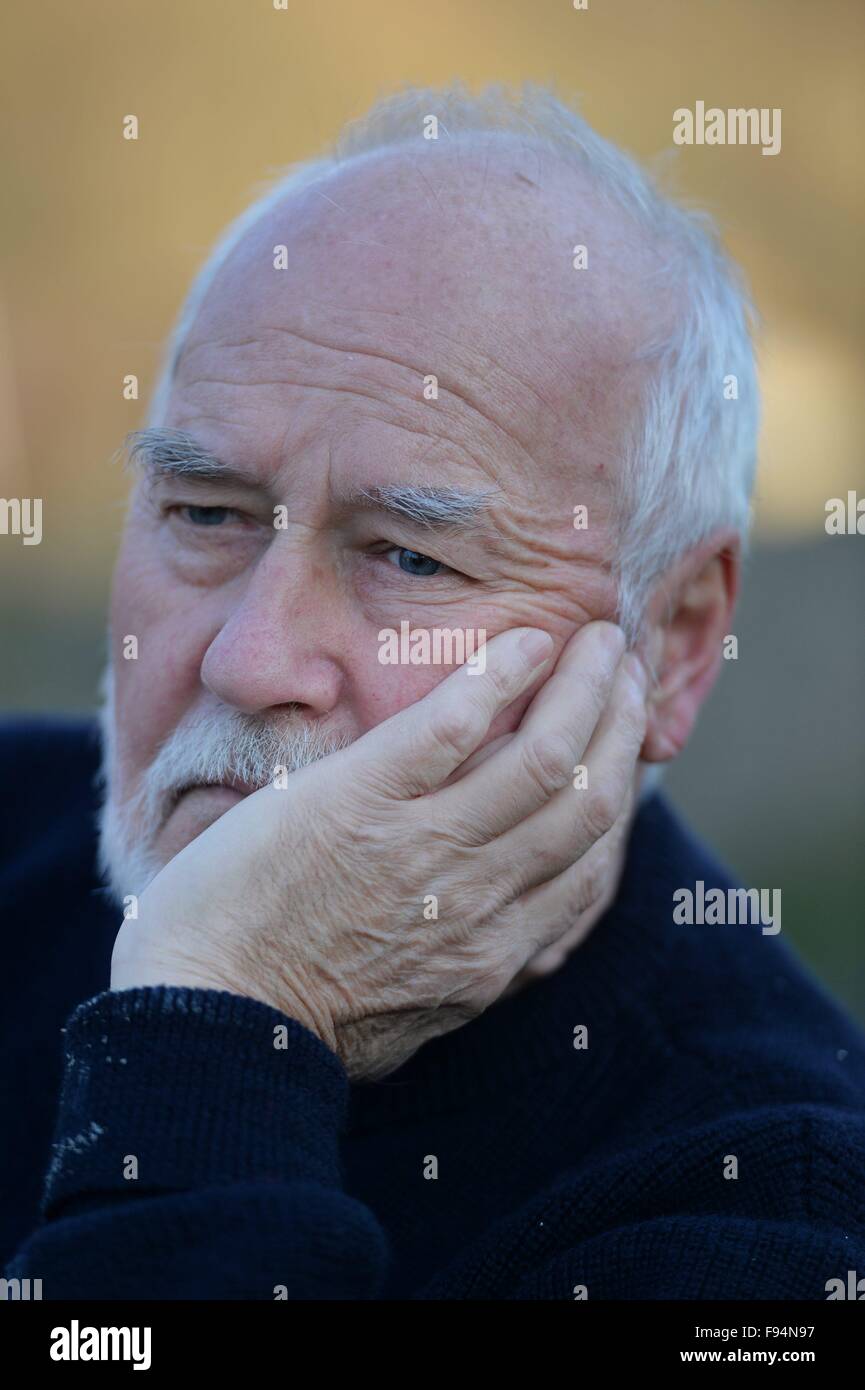 Elderly man sitting on a bank thinking, Germany, city of Osterode, 10. December 2015. Photo: Frank May Stock Photo