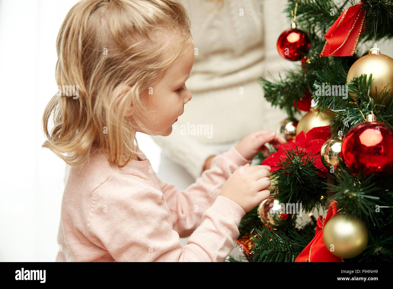 little girl decorating christmas tree at home Stock Photo - Alamy