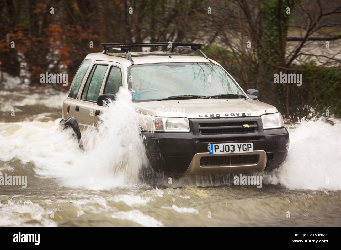 A car going through flood waters on the Ambleside, Coniston road at Rothay bridge in the Lake District on Saturday 5th December Stock Photo