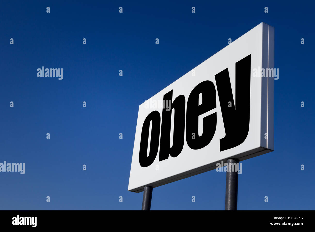 Big ad panel, embossed with the order to obey, isolated on blue sky. Stock Photo