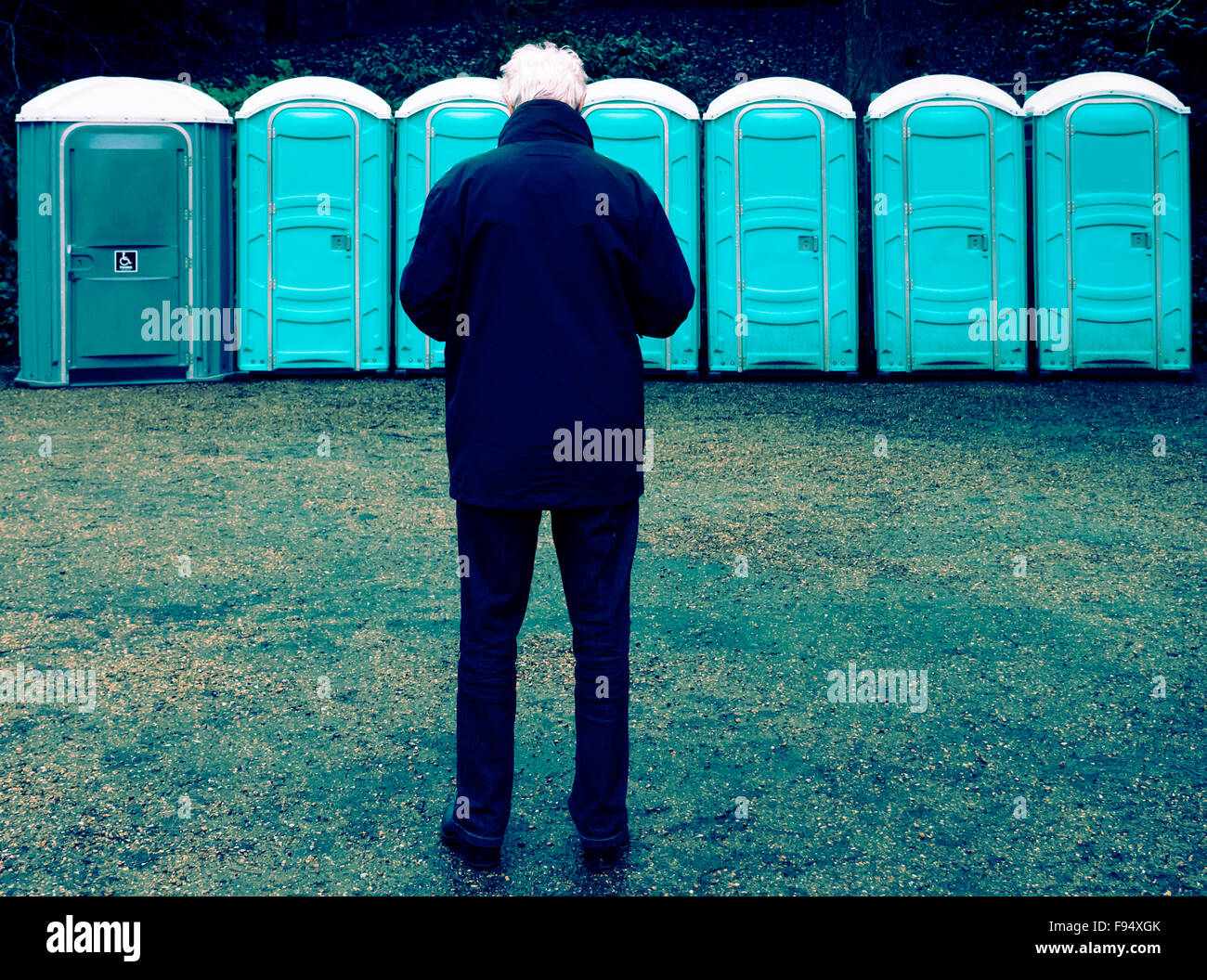 Man waiting to use a portable toilet Stock Photo