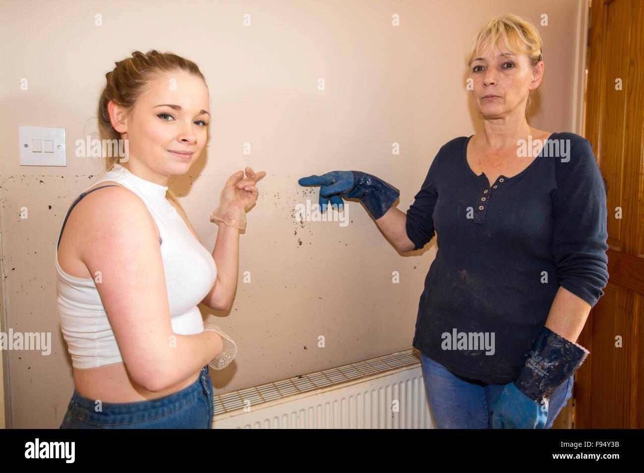 Kate and Jenny Kay point to the level the flood waters got to in their house on Warwick Road in Carlisle, Cumbria on Tuesday 8th December 2015, after torrential rain from storm Desmond. The storm set a new British record for rainfall totals in a day with 341.4mm falling in 24 hours. Stock Photo