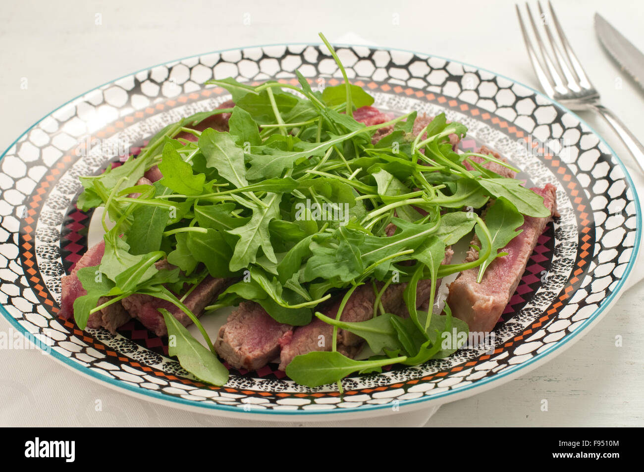 Sliced beef cooked in the oven with salt, pepper and rocket, italy Stock Photo Alamy
