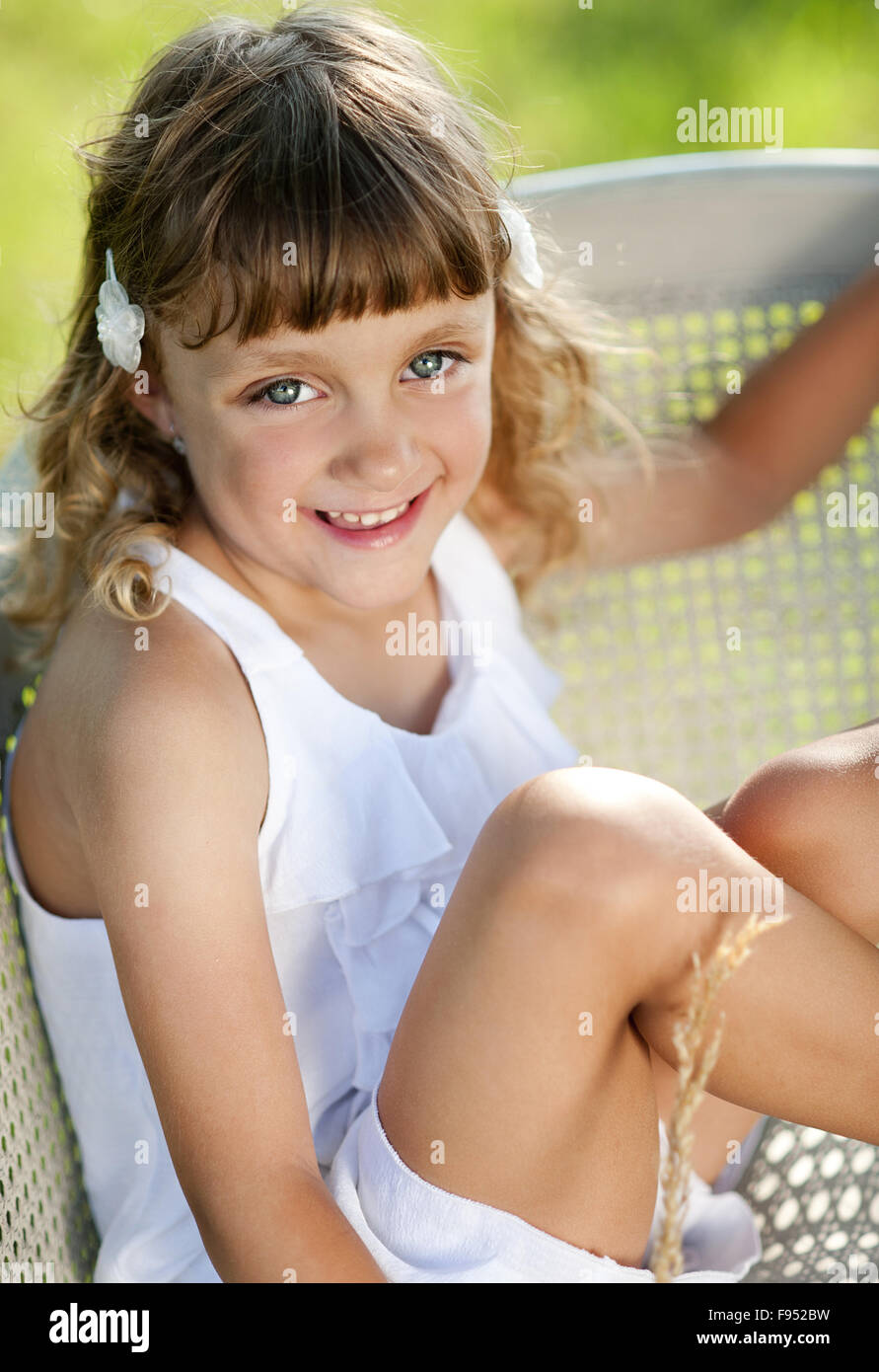 Cute little girl is enjoying leisure time with in green sunny park Stock Photo