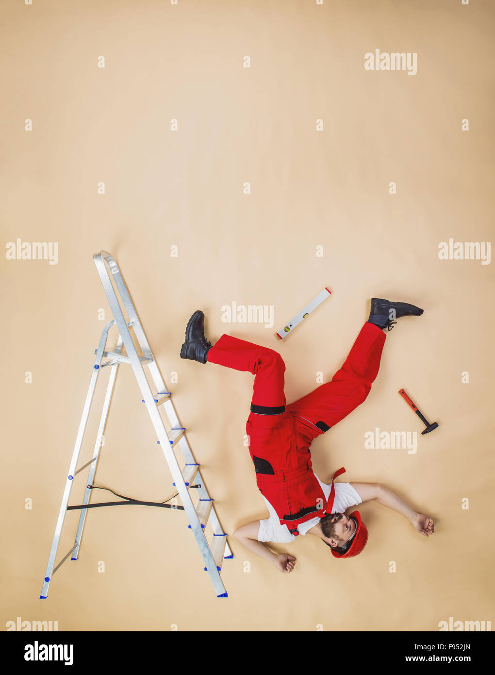 Construction worker have an accident. Funny studio pose. Stock Photo