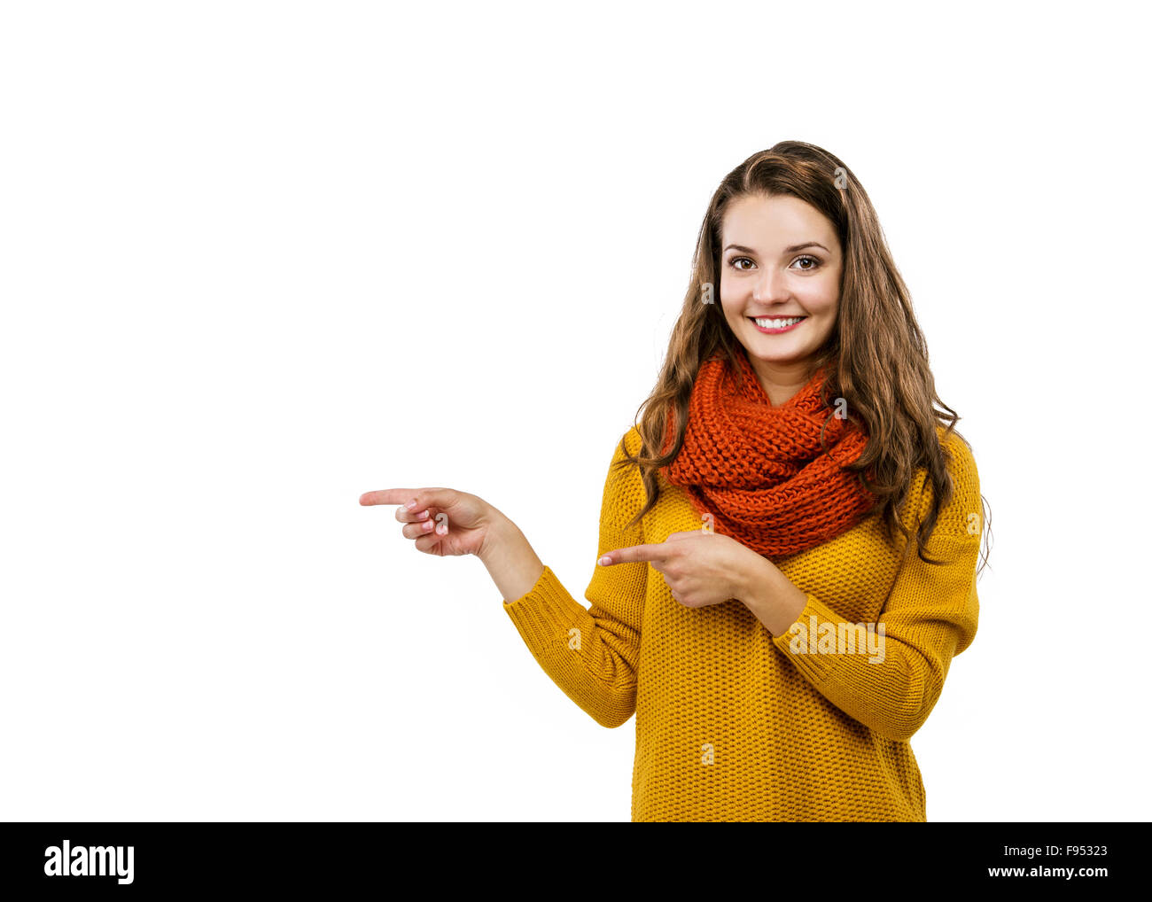 Portrait of beautiful girl in autumn clothes showing a product - empty copy space showing with her fingers, isolated on white ba Stock Photo