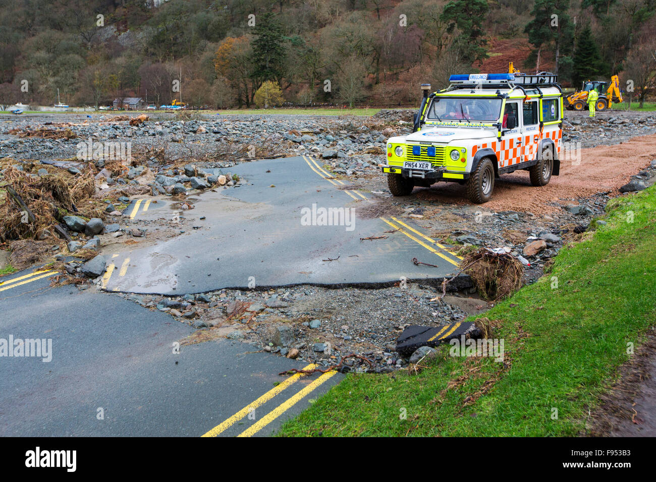 On Saturday 5th December 2015, Storm Desmond crashed into the UK, producing the UK's highest ever 24 hour rainfall total at 341.4mm. It flooded the Lakeland village Glenridding, which was just starting to repair when another period of heavy rain on Wednesday 9th December caused the Glenridding Beck to burst its banks, causing yet further destruction. This shot taken on Friday 11th December shows a road in Glenridding washed sideways by the force of the floods, with a Patterdale mountain Rescue Team Land rover crossing. Stock Photo