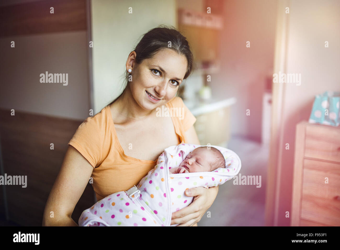 Young mother with newborn baby at home. Stock Photo