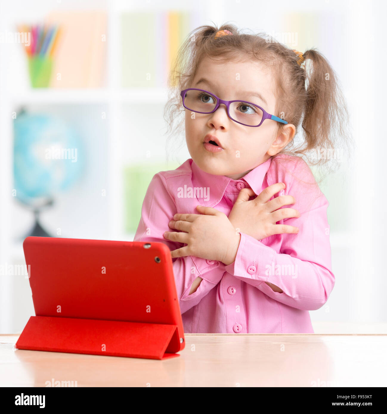 Scared kid with tablet PC in spectacles Stock Photo