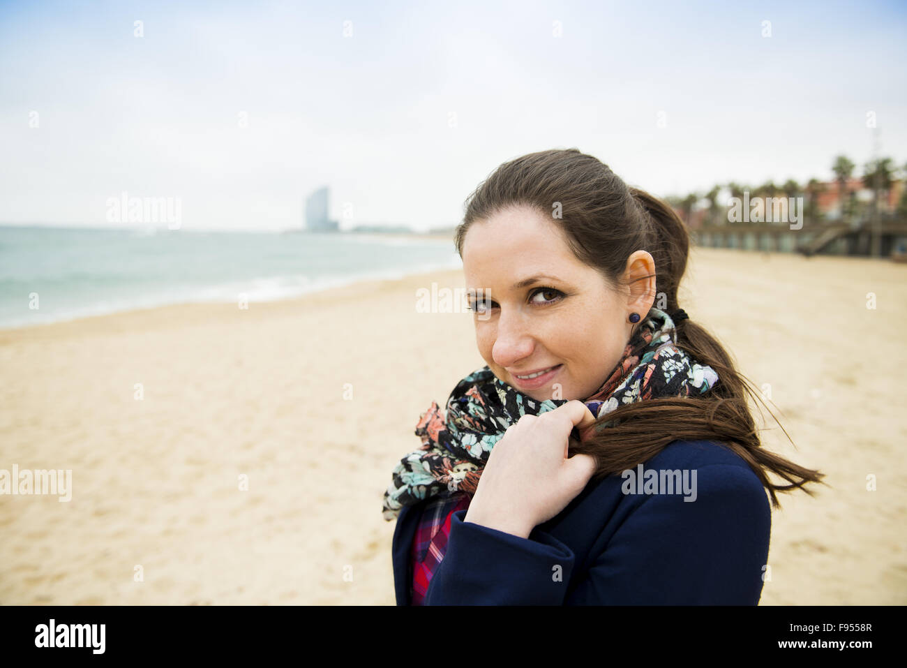 Portrait of pretty young traveler on the beach on a cold day. Stock Photo