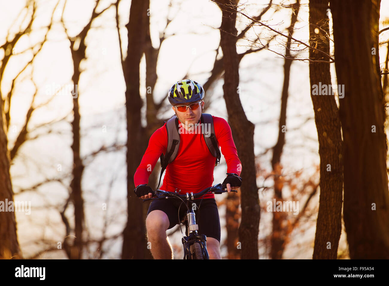 Cyclist man riding mountain bike on outdoor trail in autumn forest Stock Photo