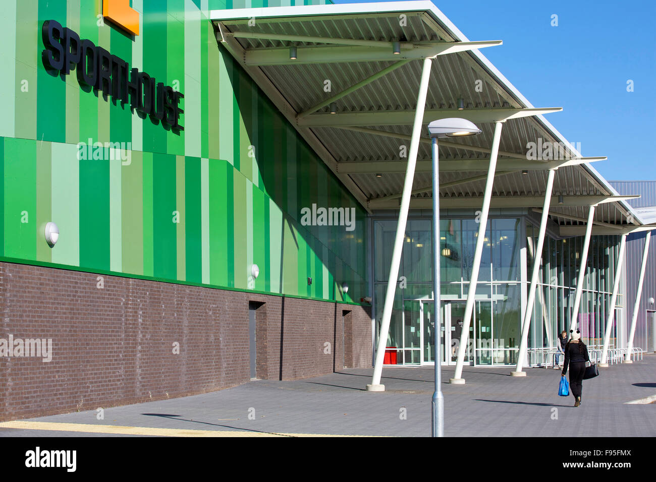 Sporthouse, Mayesbrook Park Sports Arena, Dagenham. Close view of the exterior of the Sporthouse venue and a visitor walking towards the entrance. Stock Photo