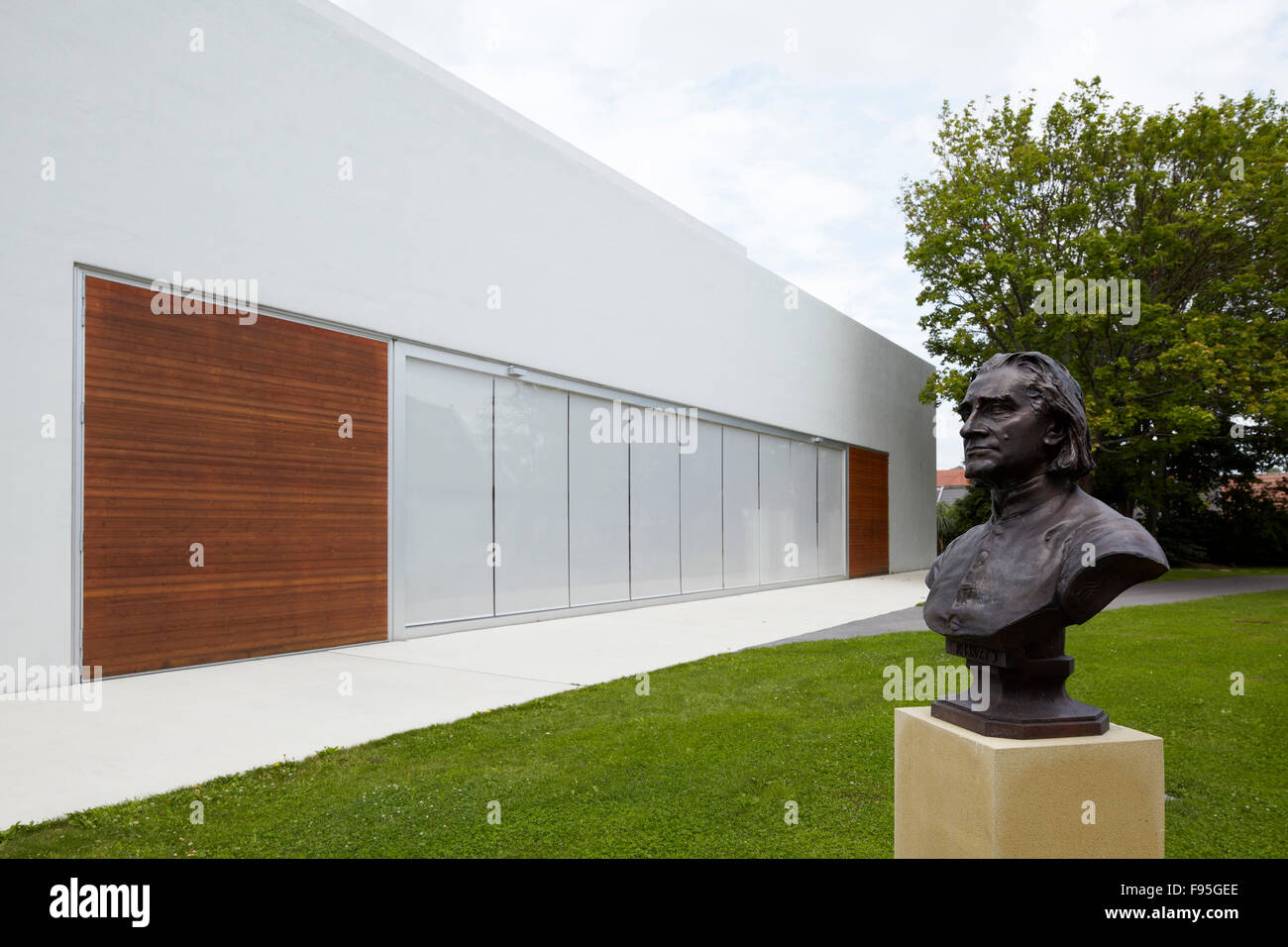 Franz Liszt Konzerthalle, Raiding, Burgenland, Austria. View of the exterior to the Franz Liszt Konzerthalle, concert hall, and a bust of a male head on the grounds. Stock Photo